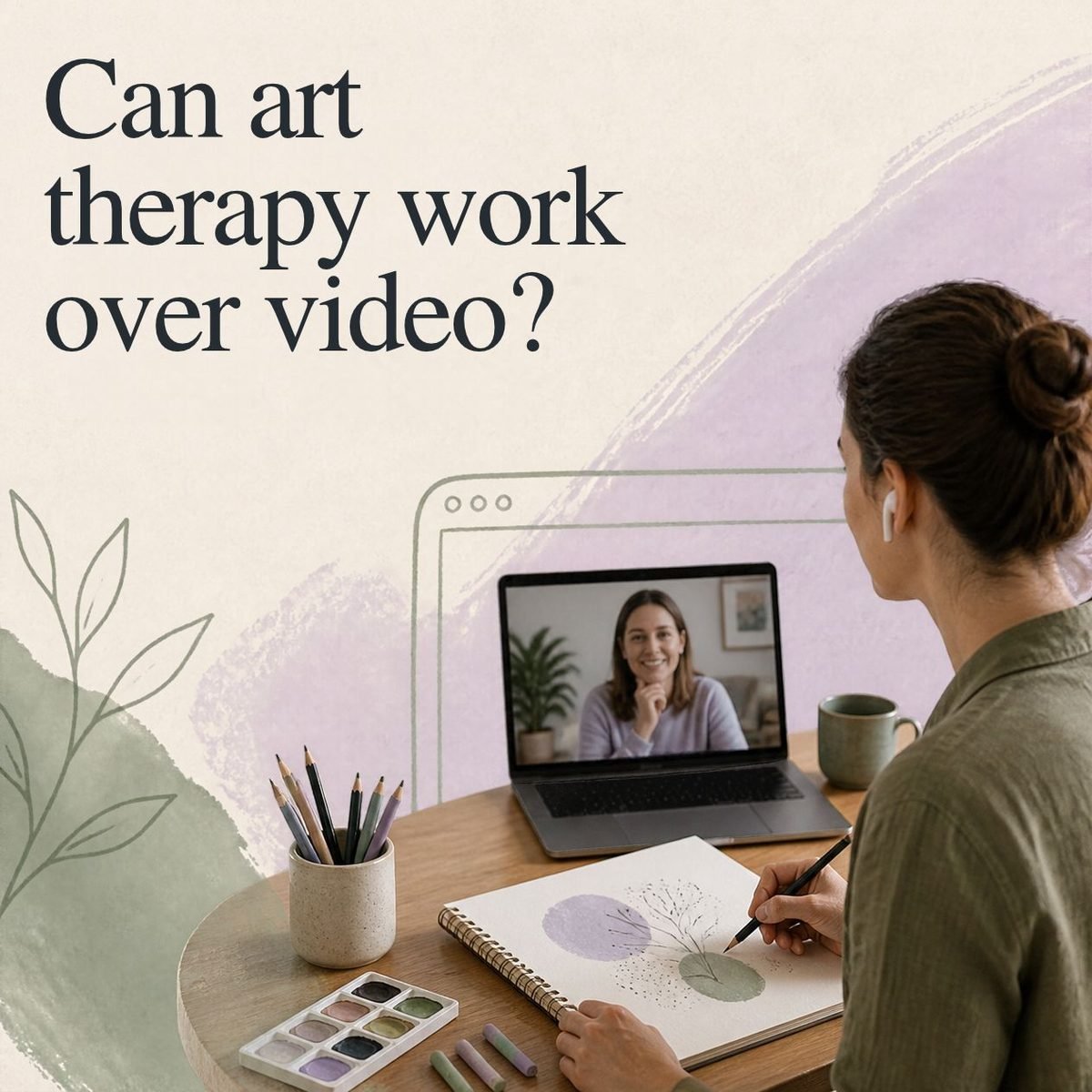 A woman drawing in a sketchbook during a video art therapy session